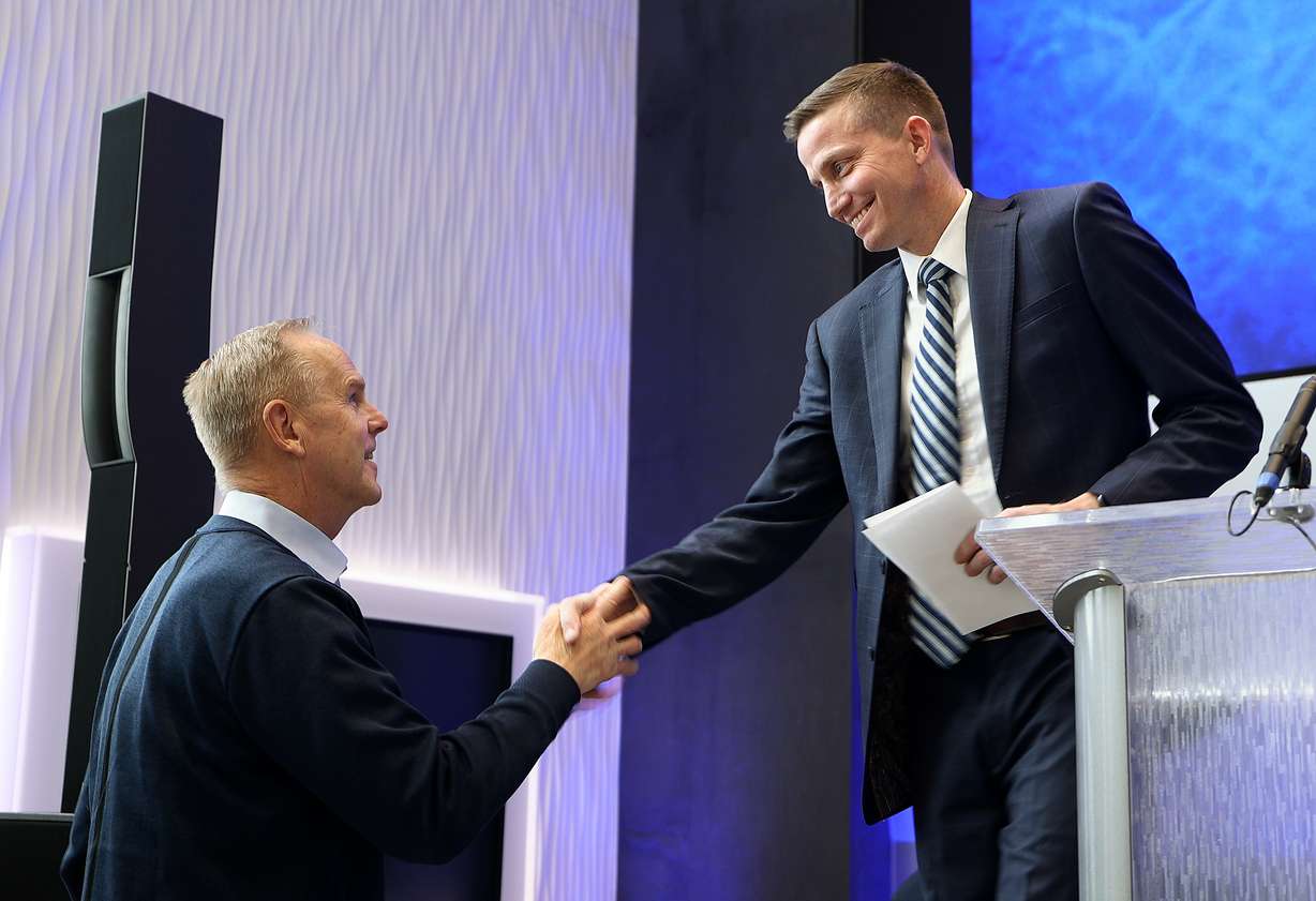 BYU director of athletics Tom Holmoe shakes hands with Lee Cummard after a press conference to introduce Cummard as the new BYU women’s basketball head coach at the Marriott Center Annex in Provo on Monday, March 31, 2025.