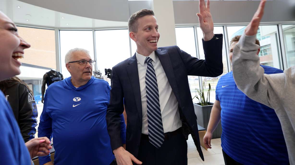 Lee Cummard gets high fives after a press conference to introduce him as the new BYU women’s basketball head coach at the Marriott Center Annex in Provo on Monday, March 31, 2025.