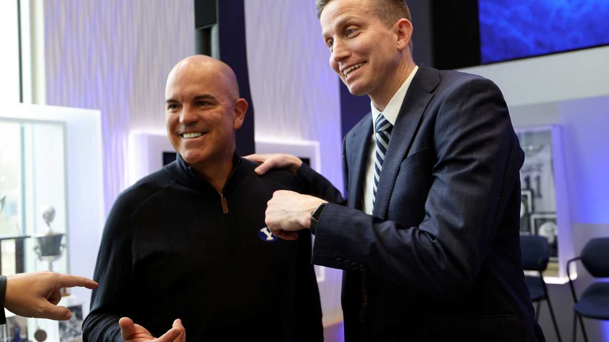 Brian Santiago, BYU deputy athletic director, and Lee Cummard talk after a press conference to introducing Cummard as the new BYU women’s basketball head coach at the Marriott Center Annex in Provo on Monday, March 31, 2025.