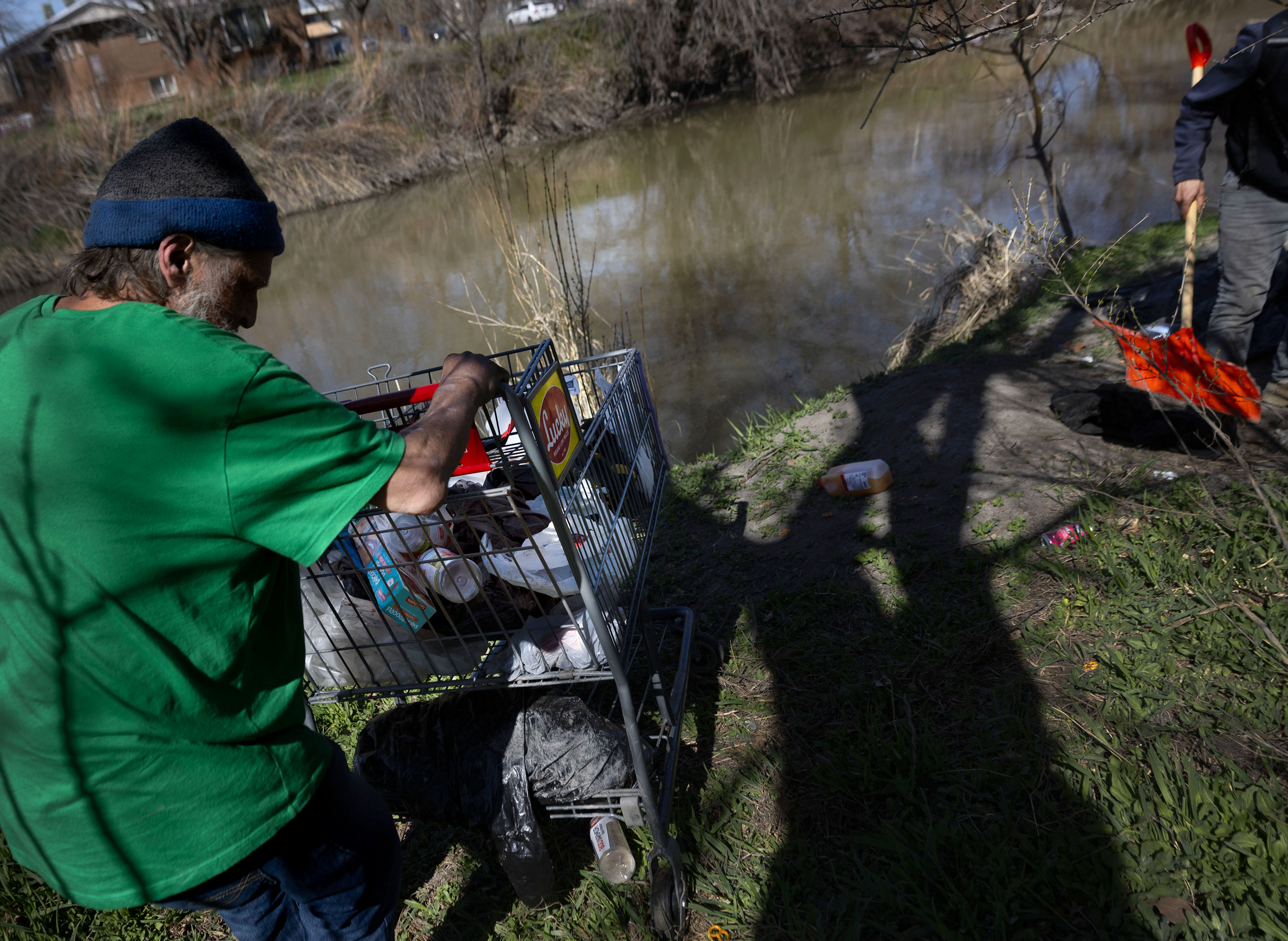 Campers remove their belongings after getting kicked out of their illegal camping spot on the Jordan River in Salt Lake City on March 22, 2024. Officials said Monday a section of the trail near Cottonwood Park is temporarily closed.