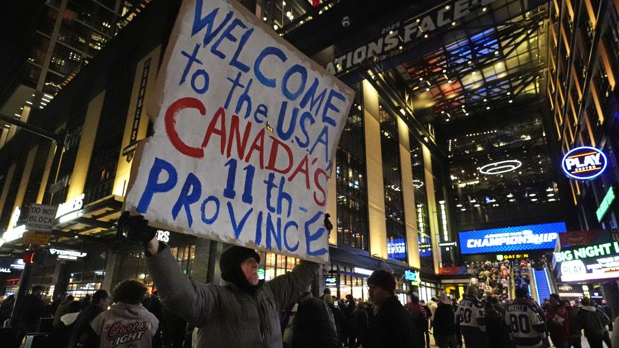 FILE - As fans enter the Boston Garden, a man holds a sign on the sidewalk prior to the 4 Nations Face-Off championship hockey game between the United States and Canada,Feb. 20, 2025, in Boston.