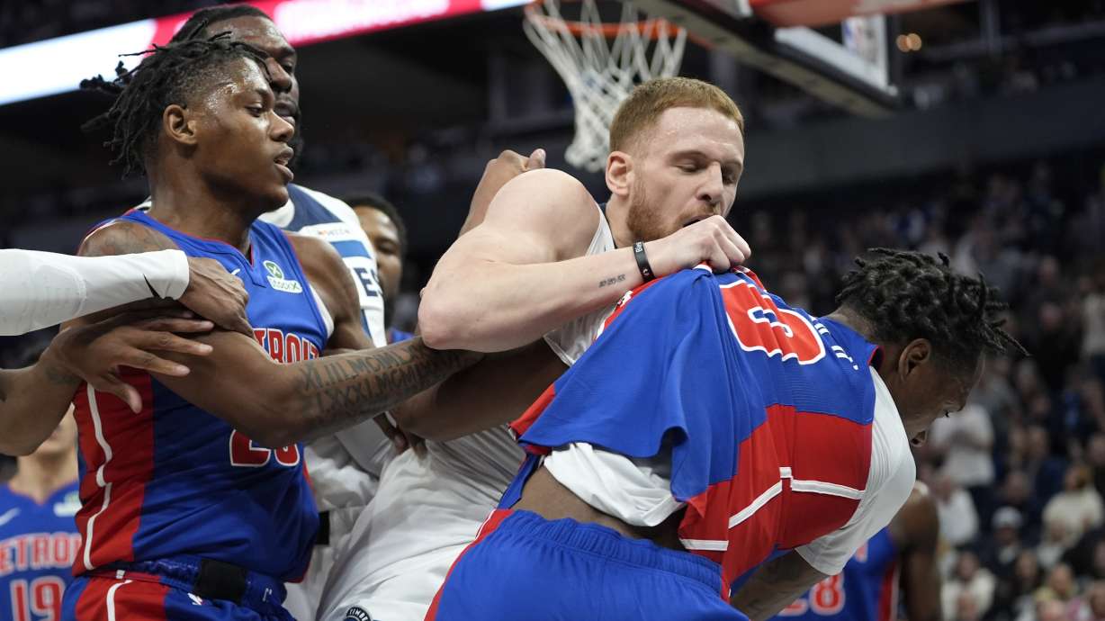 Minnesota Timberwolves guard Donte DiVincenzo (0), middle, and Detroit Pistons forward Ronald Holland II (00), right, fight during the first half of an NBA basketball game, Sunday, March 30, 2025, in Minneapolis.