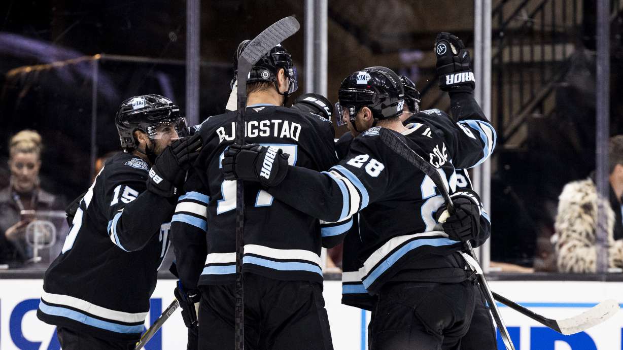 Utah Hockey Club players celebrate around center Kevin Stenlund (82) after his goal against the Calgary Flames during an NHL game held at the Delta Center in Salt Lake City on Tuesday, April 1, 2025.
