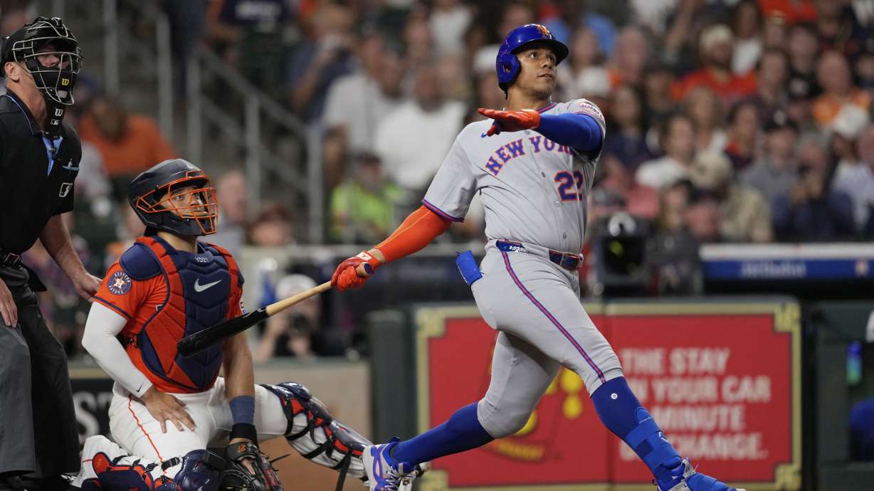 New York Mets' Juan Soto (22) hits a home run as Houston Astros catcher Yainer Diaz reaches for the pitch during the third inning of a baseball game Friday, March 28, 2025, in Houston.
