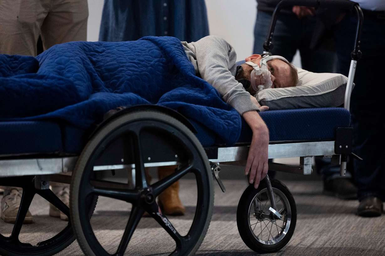 Denali Therapeutics patient fellow Seth Christensen, who has amyotrophic lateral sclerosis, listens to speakers during a ribbon cutting for Denali Therapeutics' new biomedical facility in Salt Lake City on March 27.