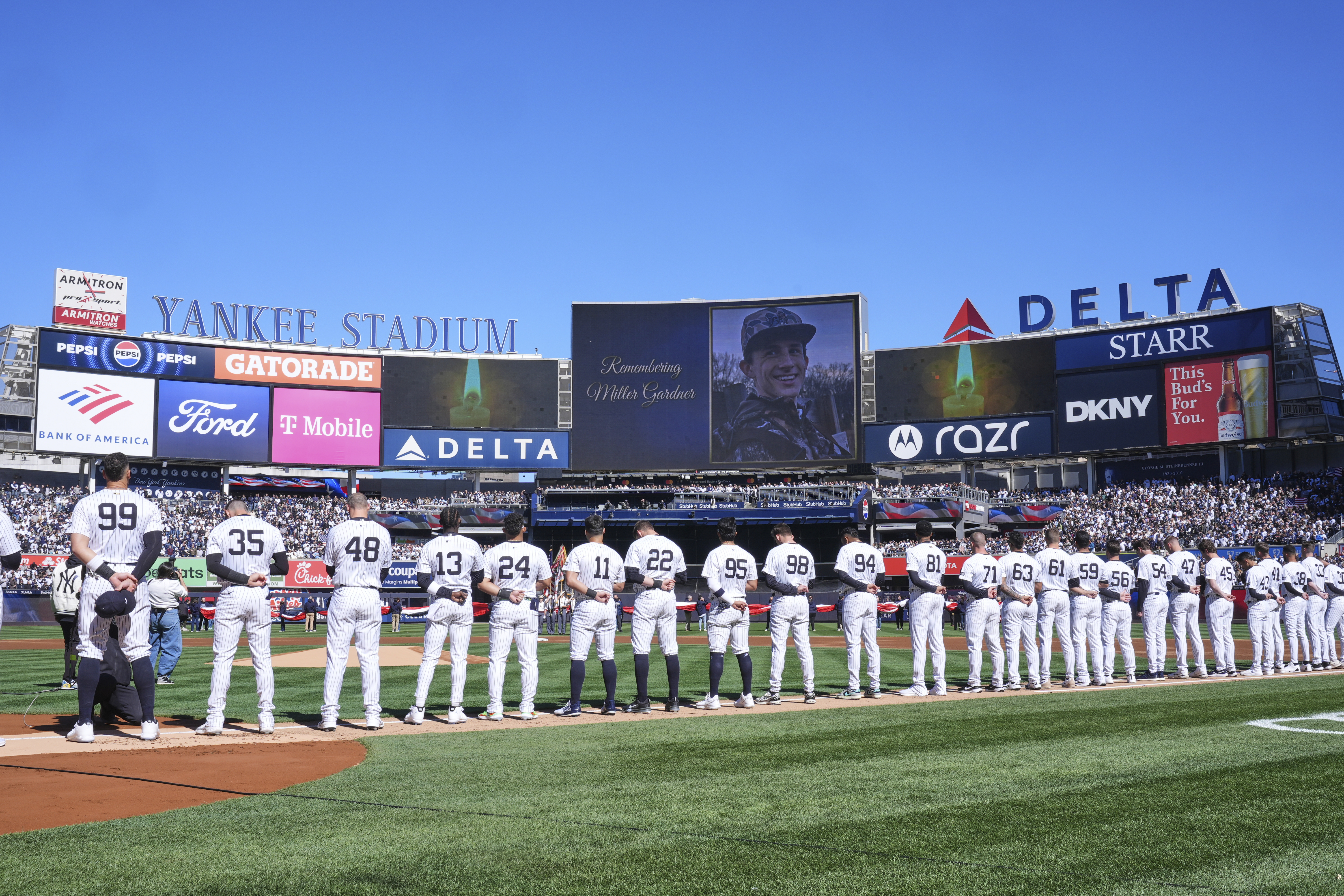 A moment of silence is observed for Miller Gardner, son of former New York Yankees player Brett Gardner, before the start of an opening-day baseball game between the Yankees and the Milwaukee Brewers at Yankee Stadium, Thursday, March 27, 2025, in New York.