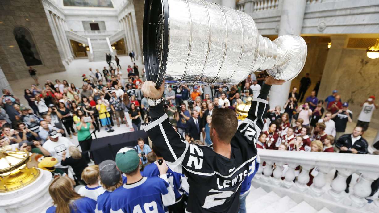Los Angeles Kings center and Utah native Trevor Lewis hoists the Stanley Cup while posing with fans at the state Capitol in Salt Lake City Wednesday, Aug. 27, 2014.