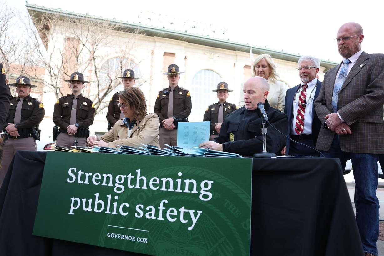Gov. Spencer Cox and Lt. Gov. Deidre M. Henderson perform a ceremonial signing of public safety legislation in Salt Lake City on Thursday.