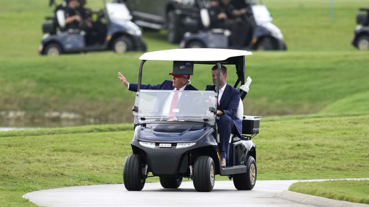 President Donald Trump, driven by his son Eric Trump, arrives at Trump National Doral during the LIV Golf Miami tournament, Thursday, April 3, 2025, in Miami.