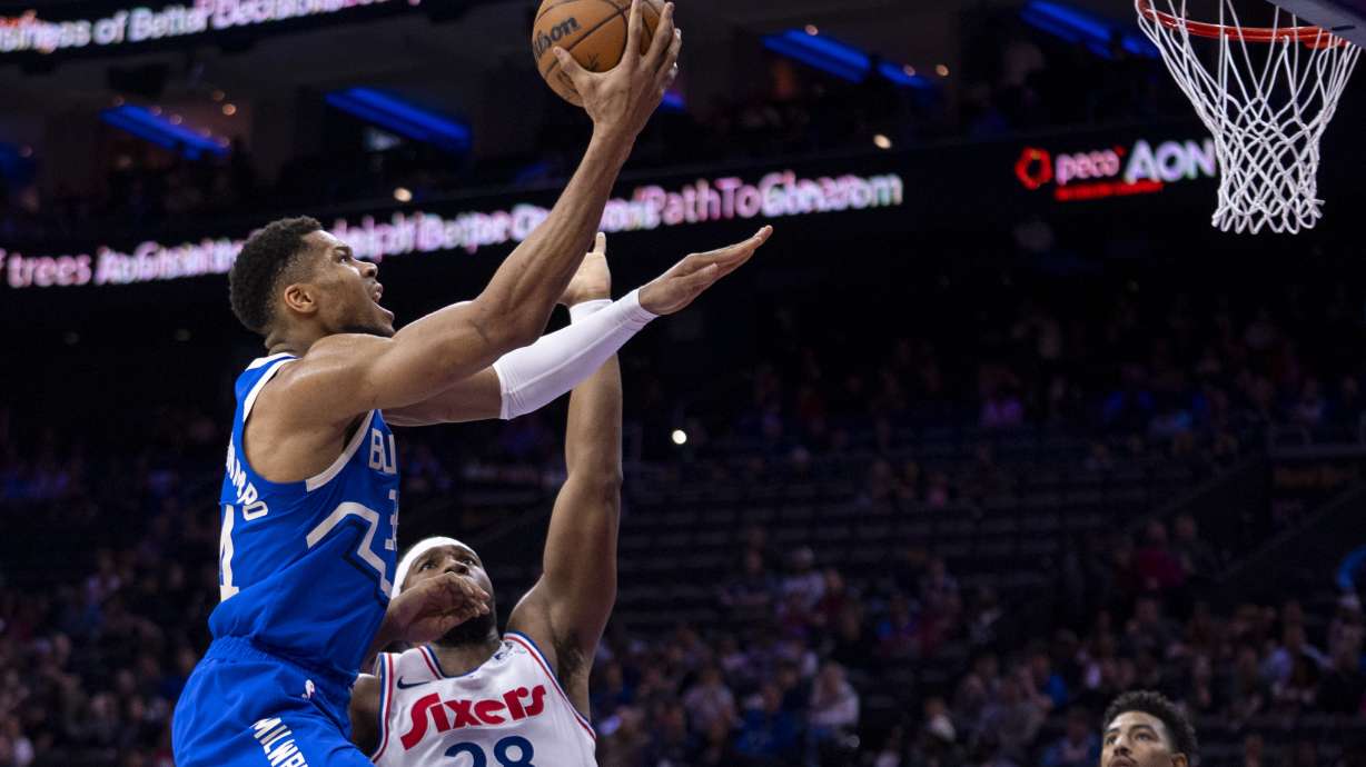 Milwaukee Bucks' Giannis Antetokounmpo, left, goes up for the show til Philadelphia 76ers' Guerschon Yabusele, right, defending during the first half of an NBA basketball game, Thursday, April 3, 2025, in Philadelphia.