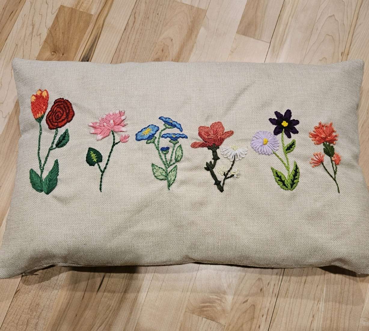 A throw pillow with embroidered flowers. Embroidery is one of several "grandma hobbies" that have made a resurgence in social media trends.