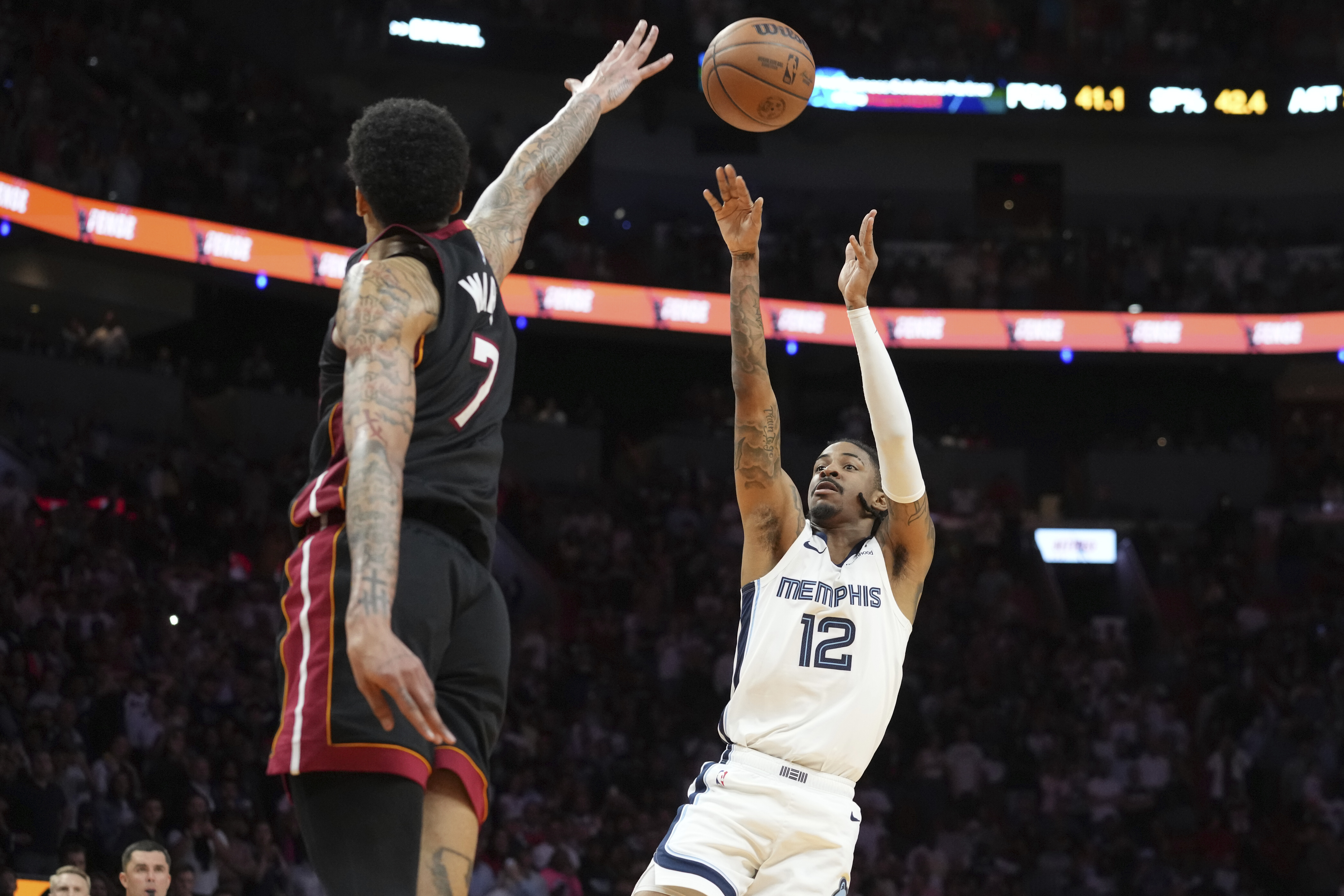 Memphis Grizzlies guard Ja Morant (12) scores the game winning basket as Miami Heat center Kel'el Ware (7) defends during the second half of an NBA basketball game, Thursday, April 3, 2025, in Miami.