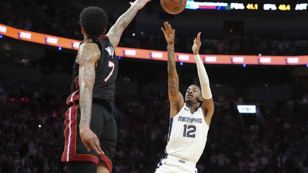 Memphis Grizzlies guard Ja Morant (12) scores the game winning basket as Miami Heat center Kel'el Ware (7) defends during the second half of an NBA basketball game, Thursday, April 3, 2025, in Miami.