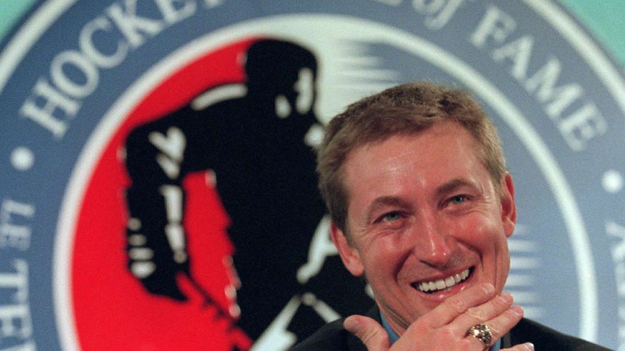 FILE - Hockey legend Wayne Gretzky laughs as he wears his new Hockey Hall of Fame ring during his induction ceremony at the Hall in Toronto, Nov. 22, 1999.