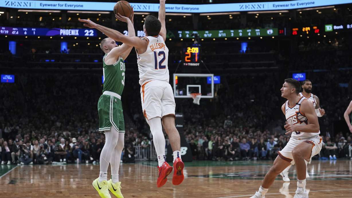 Boston Celtics forward Sam Hauser (30) takes a three-point shot against Phoenix Suns guard Collin Gillespie (12) during the first half of an NBA basketball game, Friday, April 4, 2025, in Boston.