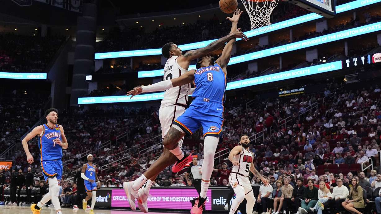 Houston Rockets forward Jabari Smith Jr., center left, fouls Oklahoma City Thunder forward Jalen Williams (8) during the first half of an NBA basketball game in Houston, Friday, April 4, 2025.