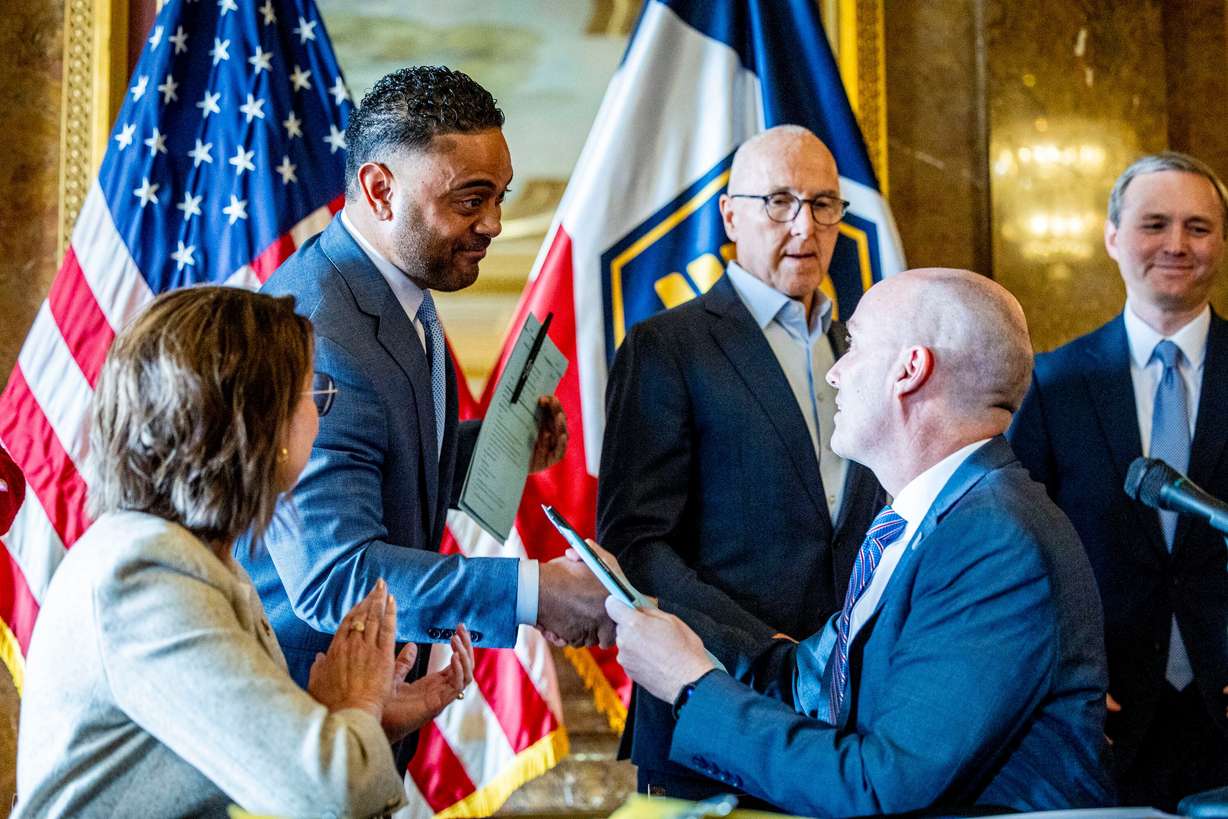 Utah Gov. Spencer Cox shakes hands with Rep. Doug Fiefia, R-Herriman, after signing a ceremonial copy of HB418, the Digital Choice Act, which Fiefia sponsored, during a press conference to address online safety, student focus and digital choice held in the gold room of the Capitol in Salt Lake City on Friday, April 4, 2025.