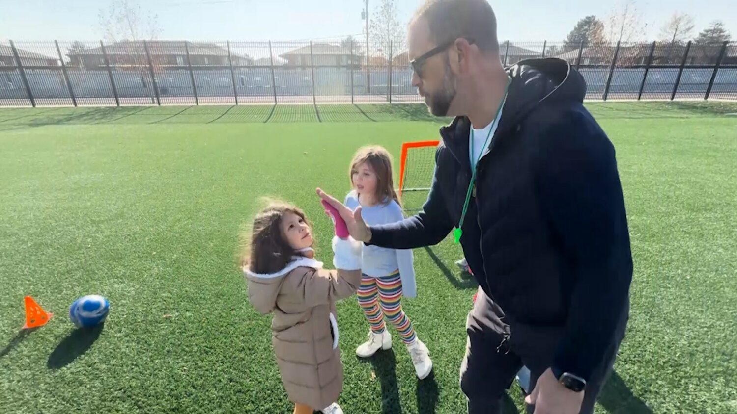 Adam Miles high-fiving young kids who are part of his program.
