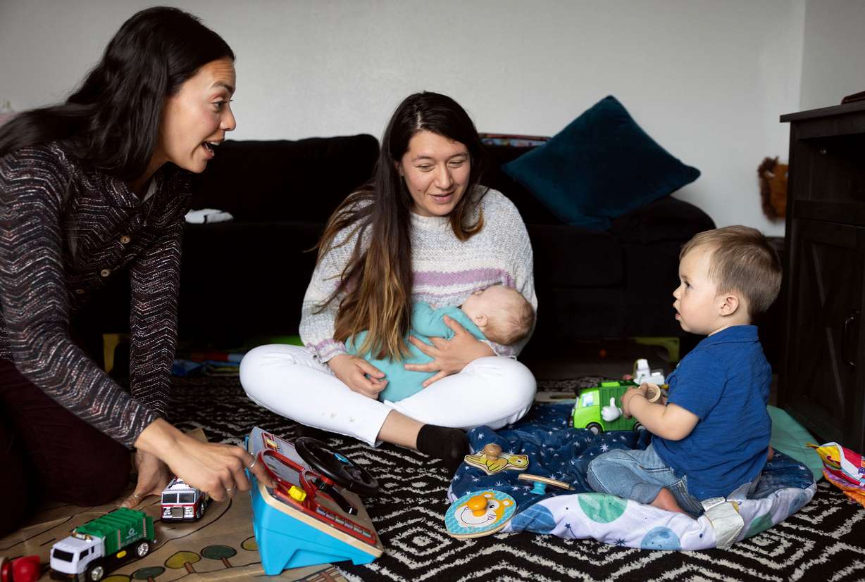 Children’s Service Society of Utah parent educator Kat Lora plays with Theo as Theo’s mother, Gabriela Caro, feeds Luca at the Williams Caro home in West Valley on Thursday, April 3, 2025. Lora was visiting the Williams Caro family as part of the home visitation program of the group.