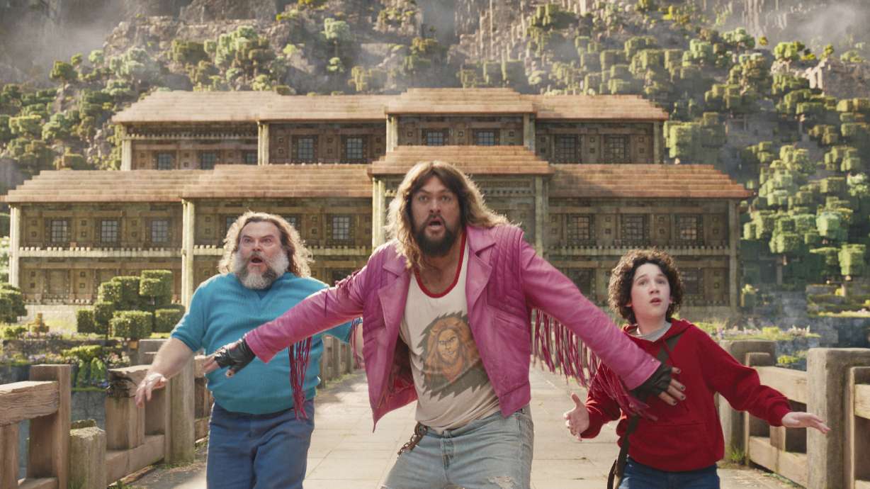 This image shows, from left, Jack Black, Jason Momoa and Sebastian Hansen in a scene from "A Minecraft Movie." The movie is smashing all box office projections.