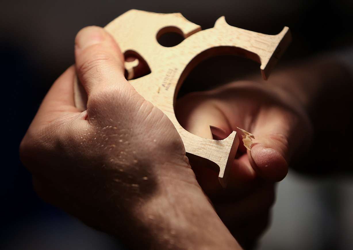 Adam Day, Day Violins owner, carves a custom cello bridge at Day Violins in Murray on March 20.