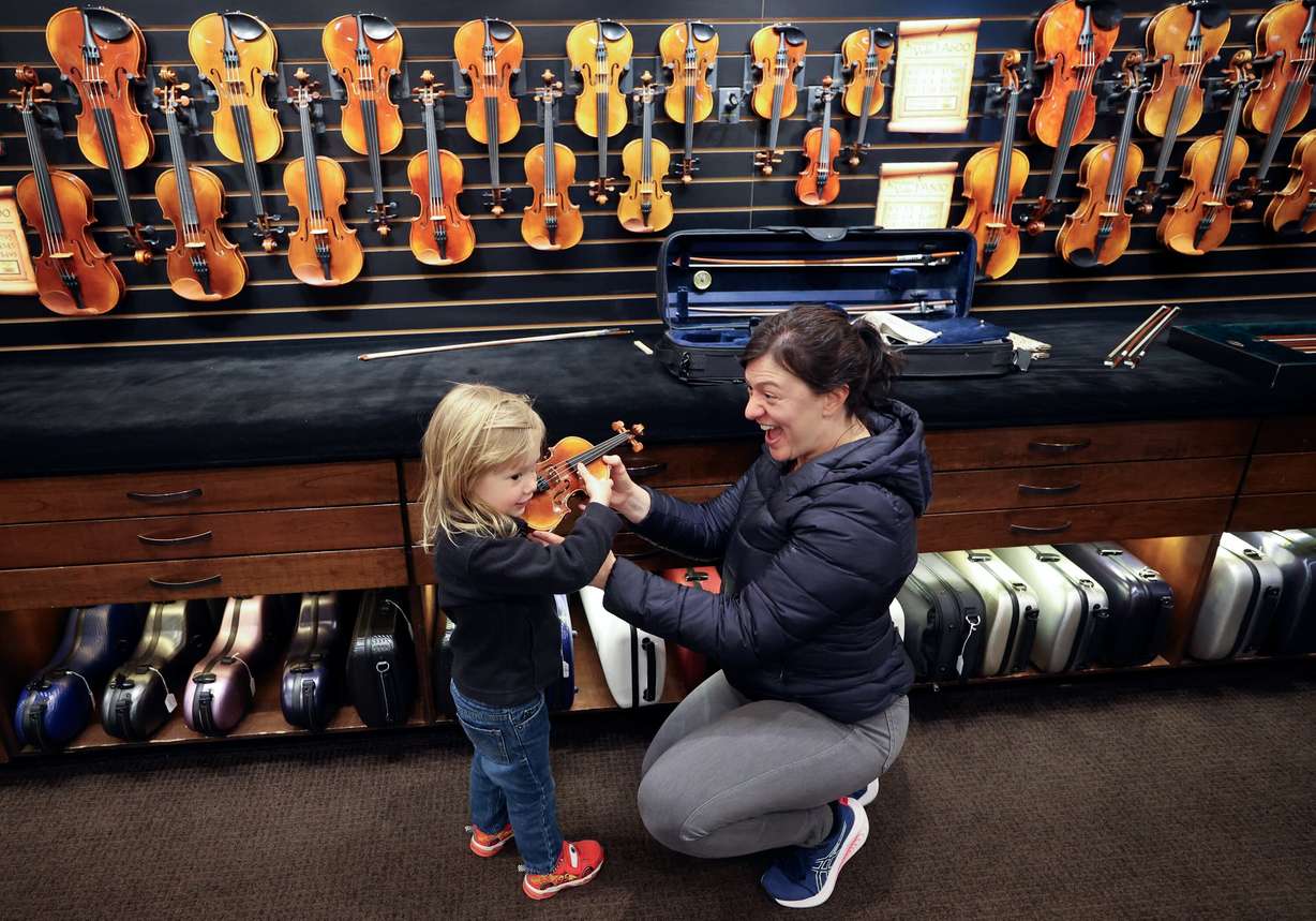 Enzo Vecchiarelli, 3, checks out a violin with his mother Nicolle Atkinson, who is a violin teacher, as they visit Day Violins in Murray on March 20.