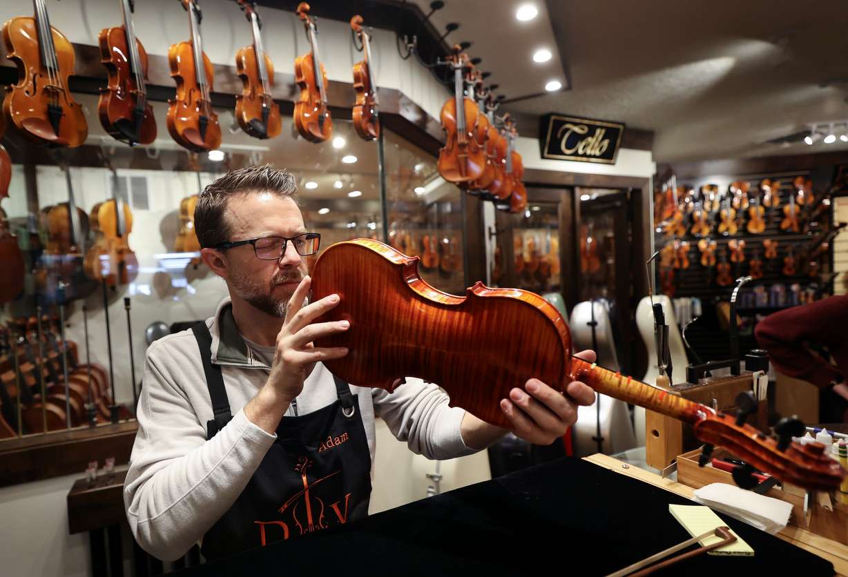Adam Day, Day Violins owner, inspects a customer’s violin brought in for repairs at Day Violins in Murray on March 20.