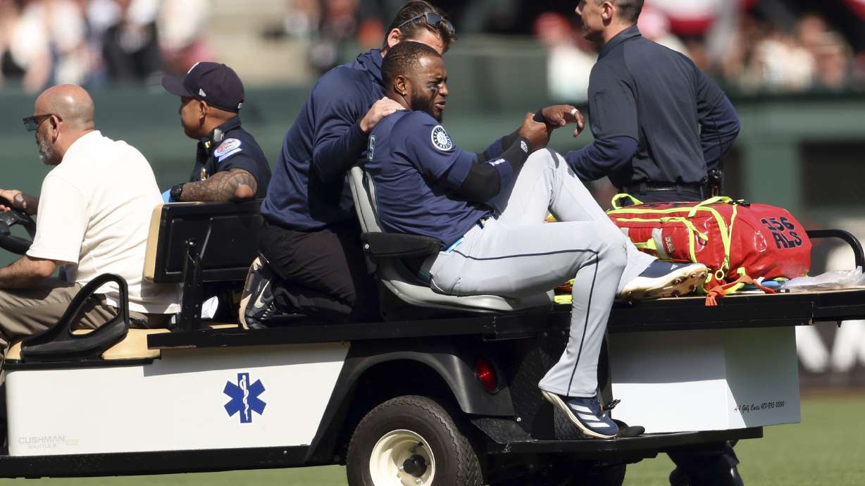 Seattle Mariners' Victor Robles holds his wrist after an injury in the ninth inning of a baseball game against the San Francisco Giants in San Francisco on Sunday, April 6, 2025.