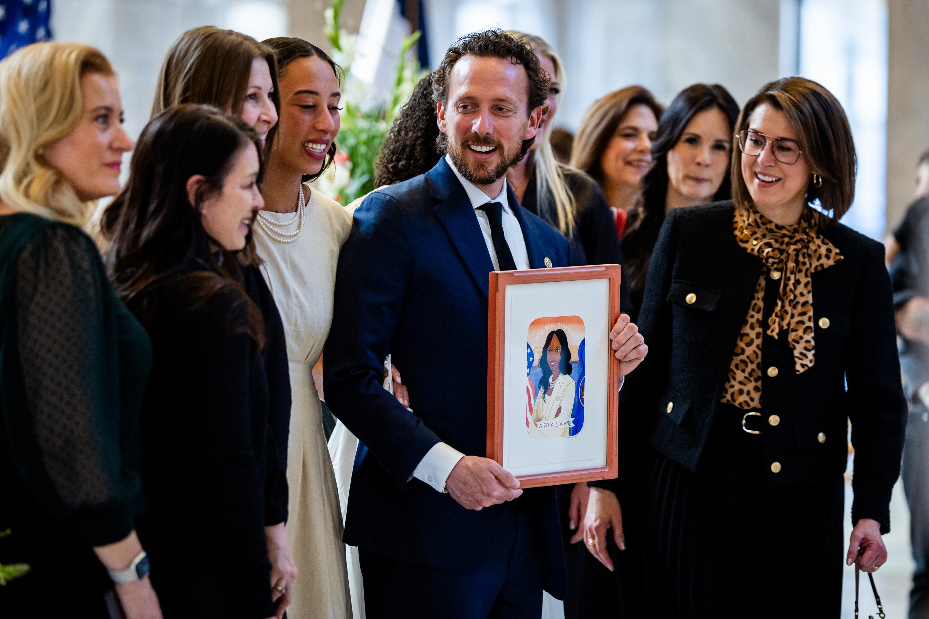 Mia Love’s husband, Jason Love, center, holds a portrait of his late wife after Lt. Gov. Deidre Henderson, far right, gifted Mia Love’s family with the illustration of Mia Love at a public viewing to honor Congresswoman Mia Love’s memory held at the State Capitol rotunda in Salt Lake City on Sunday.
