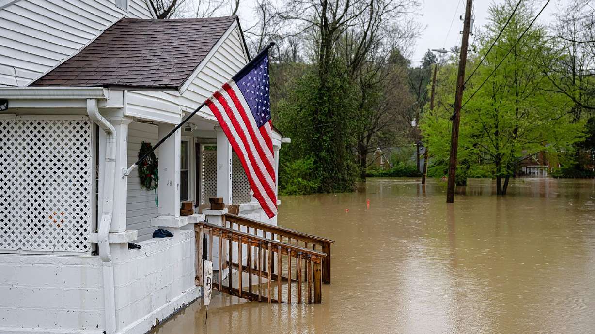 An American flag flies on the porch of a home in a flooded neighborhood on Sunday, in Frankfort, Kentucky.