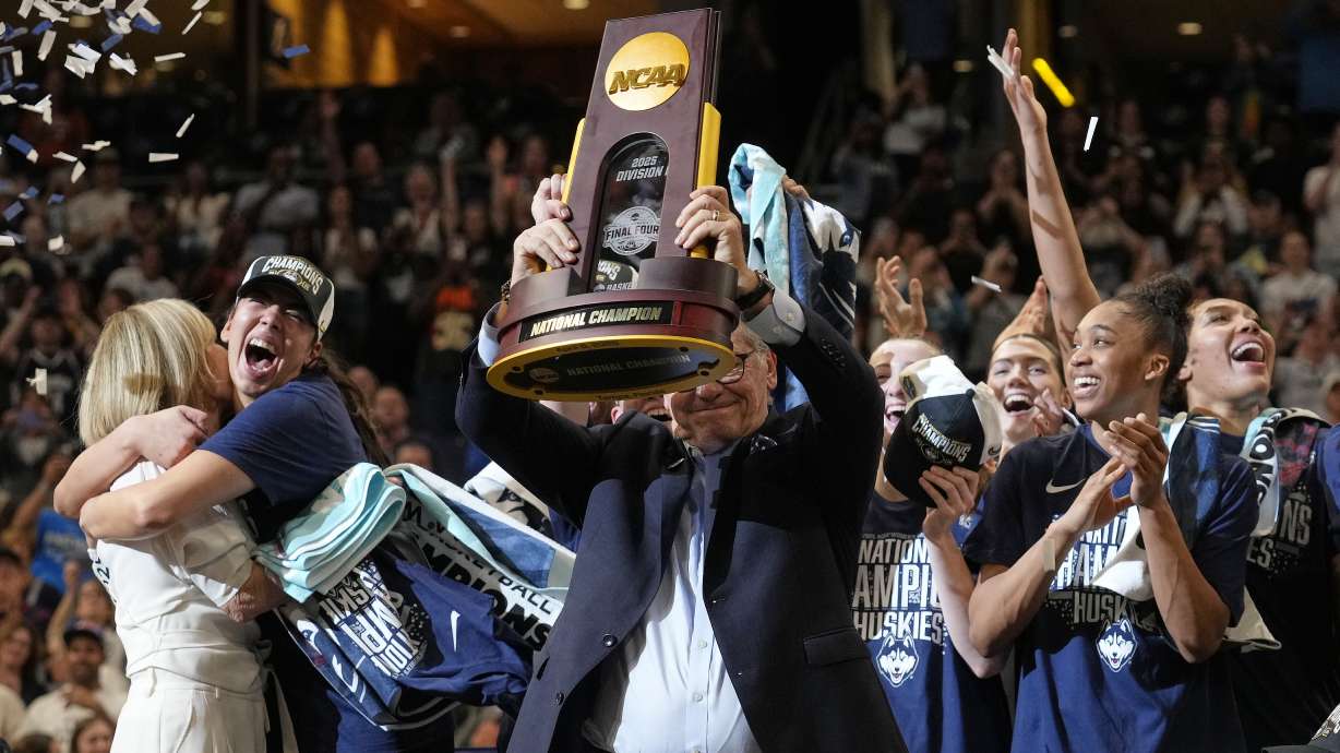 UConn head coach Geno Auriemma holds up the championship trophy after UConn defeated South Carolina in the national championship game at the Final Four of the women's NCAA college basketball tournament, Sunday, April 6, 2025, in Tampa, Fla.