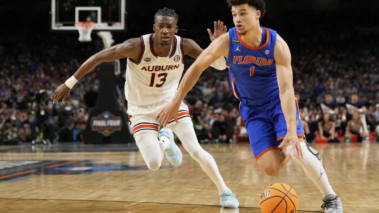 Florida guard Walter Clayton Jr. drives around Auburn guard Miles Kelly during the second half in the national semifinals at the Final Four of the NCAA college basketball tournament, Saturday, April 5, 2025, in San Antonio.