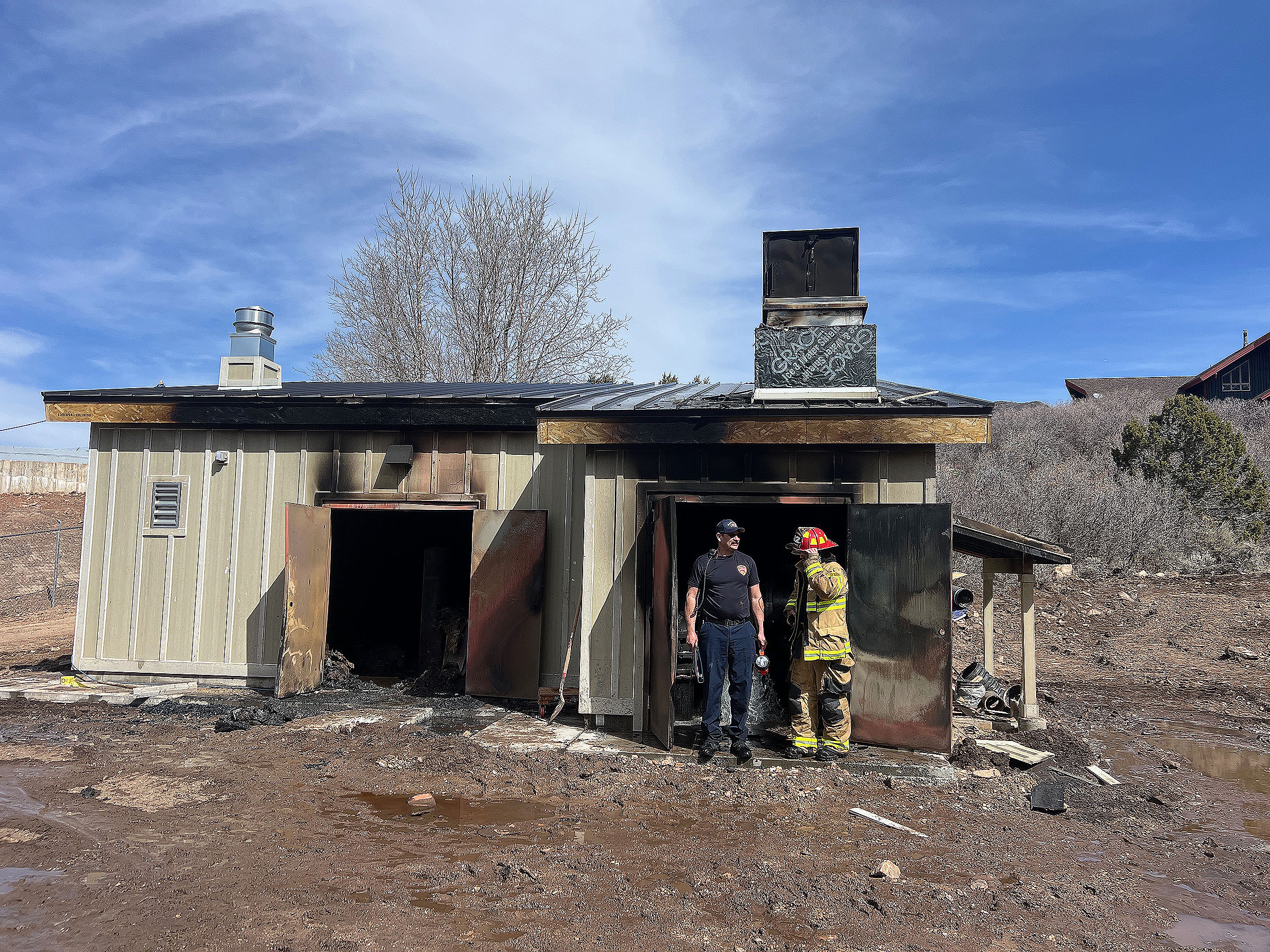 Firefighters investigate a burned pump house in Oakley, Summit County, after one person was severely burned there in an explosion on Monday morning.