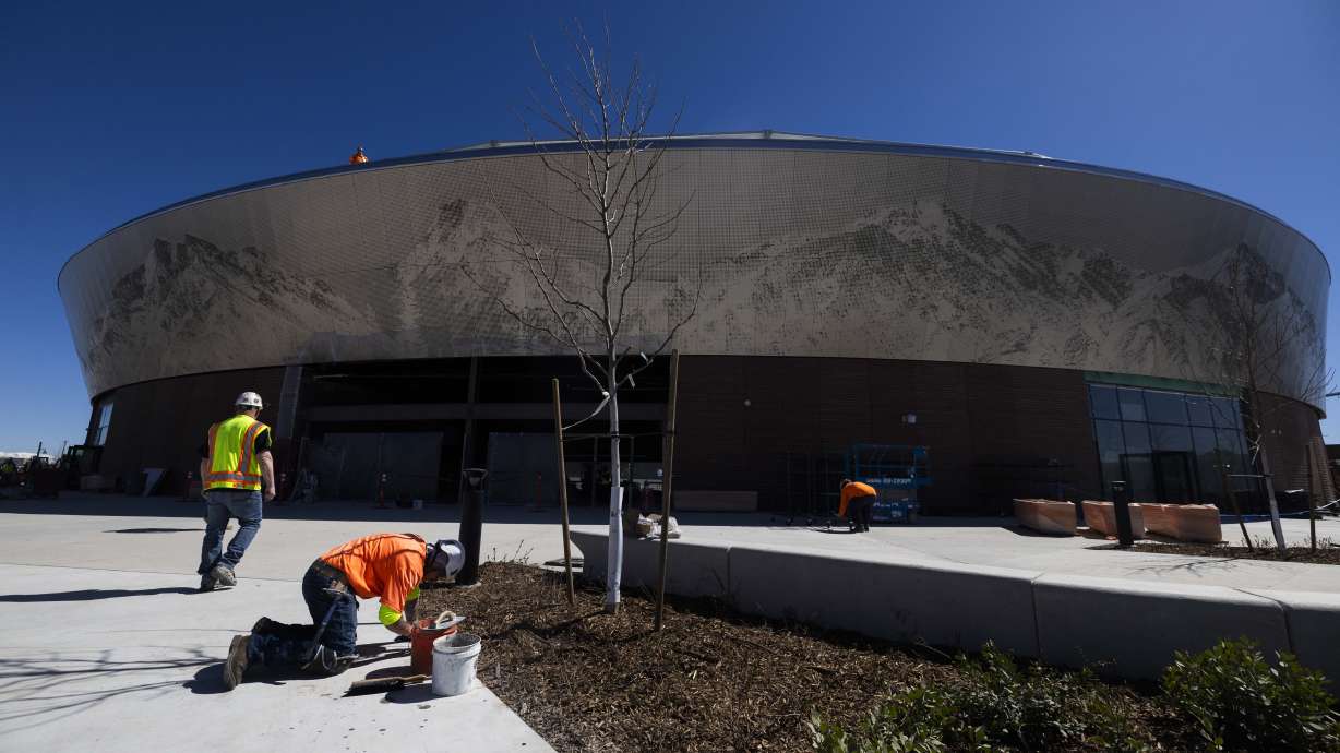 Construction workers work on the area surrounding the Salt Lake Bees' new baseball stadium, at The Ballpark at America First Square in South Jordan on March 26. The team's first game in the stadium is on Tuesday.
