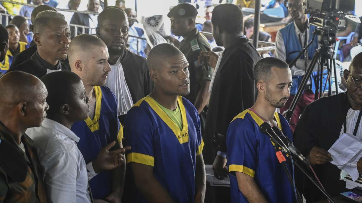 From left, Tyler Thompson Jr., Marcel Malanga and Benjamin Reuben Zalman-Polun, all American citizens, in Kinshasa, Congo, with 52 other defendants, June 7, 2024. They were jailed over a failed coup attempt and are now in U.S. custody after their sentences were commuted last week.