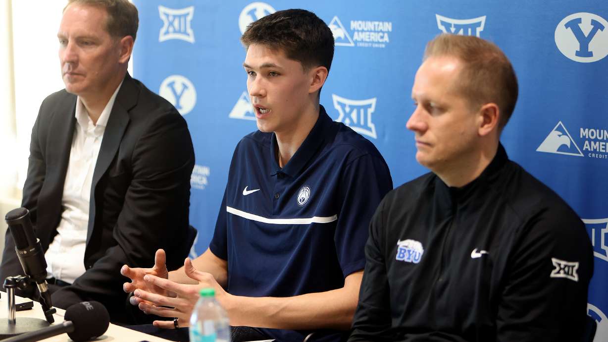 BYU point guard Egor Demin talks during a press conference about his plans to enter the NBA draft at the Marriott Center Annex in Provo on Tuesday, April 8, 2025. Travis Hansen, a former BYU basketball player and mentor to Demin, is on the left. BYU head basketball coach Kevin Young is on the right.
