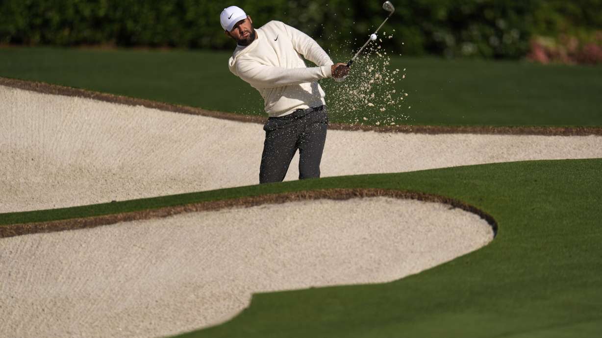 Scottie Scheffler hits from the bunker on the practice green during a practice round at the Masters golf tournament, Tuesday, April 8, 2025, in Augusta, Ga.