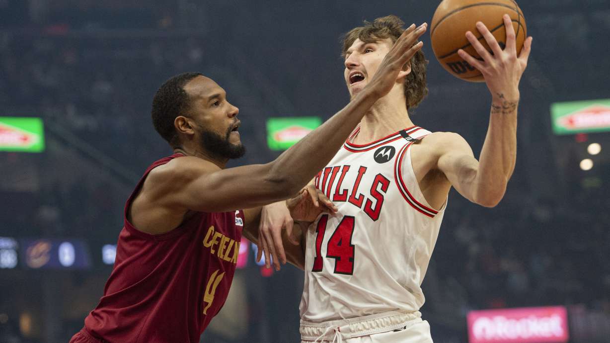 Cleveland Cavaliers' Evan Mobley (4) defends as Chicago Bulls' Matas Buzelis (14) tries to pass during the first half of an NBA basketball game in Cleveland, Tuesday, April 8, 2025.