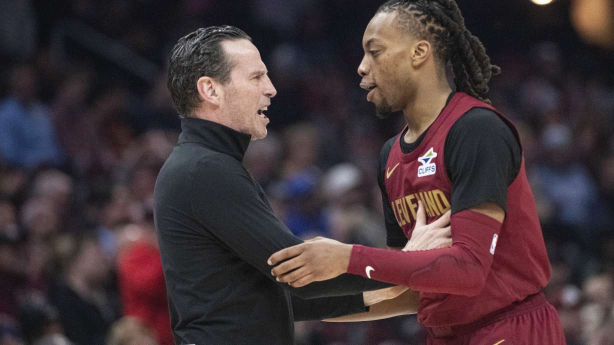 Cleveland Cavaliers head coach Kenny Atkinson, left, congratulates Darius Garland, right, after he made a three-point shot against the Chicago Bulls during the first half of an NBA basketball game in Cleveland, Tuesday, April 8, 2025.