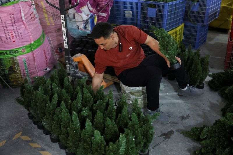An employee works to produce artificial Christmas trees at a factory in Shaoxing, Zhejiang province, China, Wednesday.