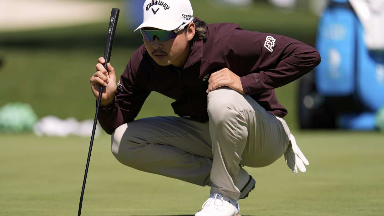 Min Woo Lee, of Australia, lines up a shot on the putting green during a practice round at the Masters golf tournament, Tuesday, April 8, 2025, in Augusta, Ga.