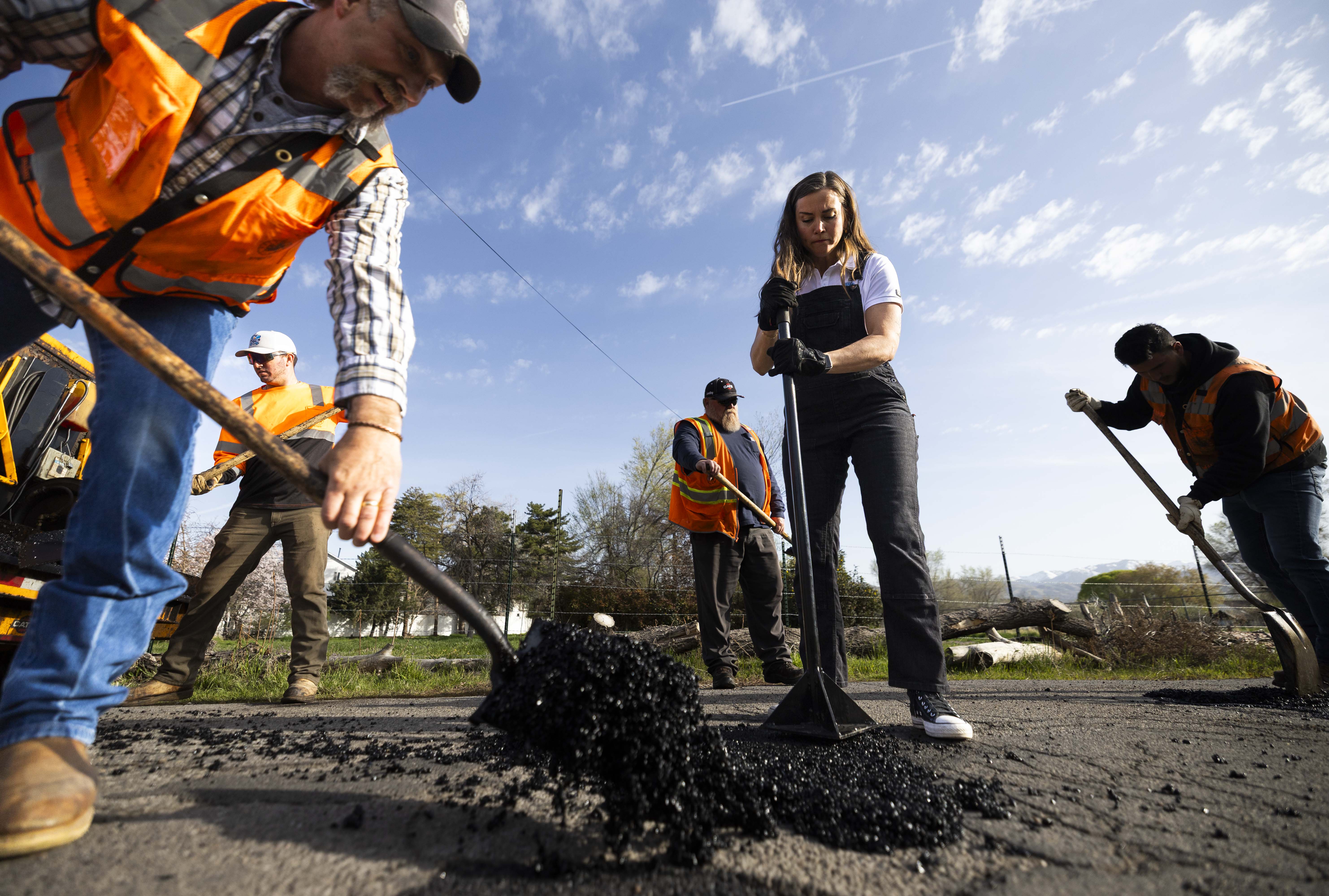 Salt Lake City Mayor Erin Mendenhall helps fill a pothole Wednesday, kicking off "Pothole Palooza," during which street crews will work to fix thousands of potholes this week in Salt Lake City.
