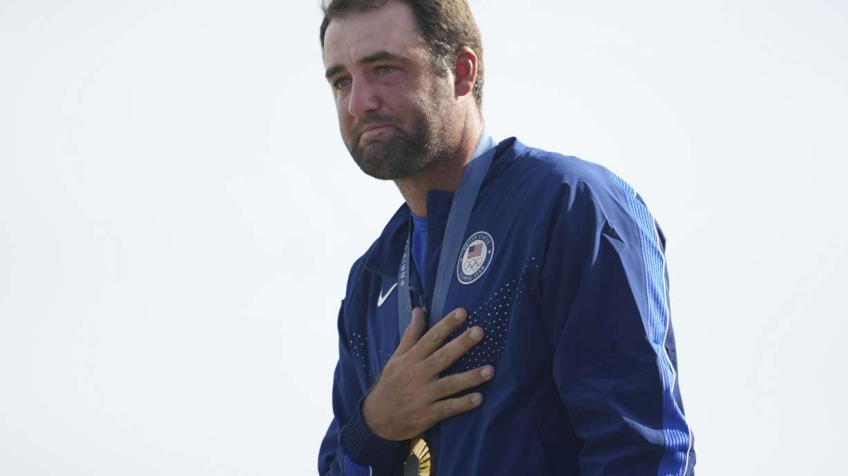 FILE - Gold medalist Scottie Scheffler, of the United States, cries as the national anthems are played during the medal ceremony for men's golf at the 2024 Summer Olympics, Sunday, Aug. 4, 2024, at Le Golf National in Saint-Quentin-en-Yvelines, France.