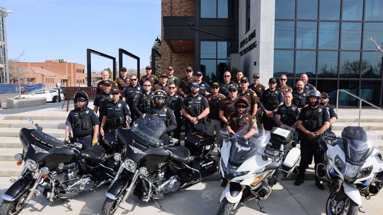 Utah troopers and police officers working to minimize distracted driving pose outside the police department in Lehi on Tuesday. Multiple agencies are identifying offenders, with some using unmarked vehicles.