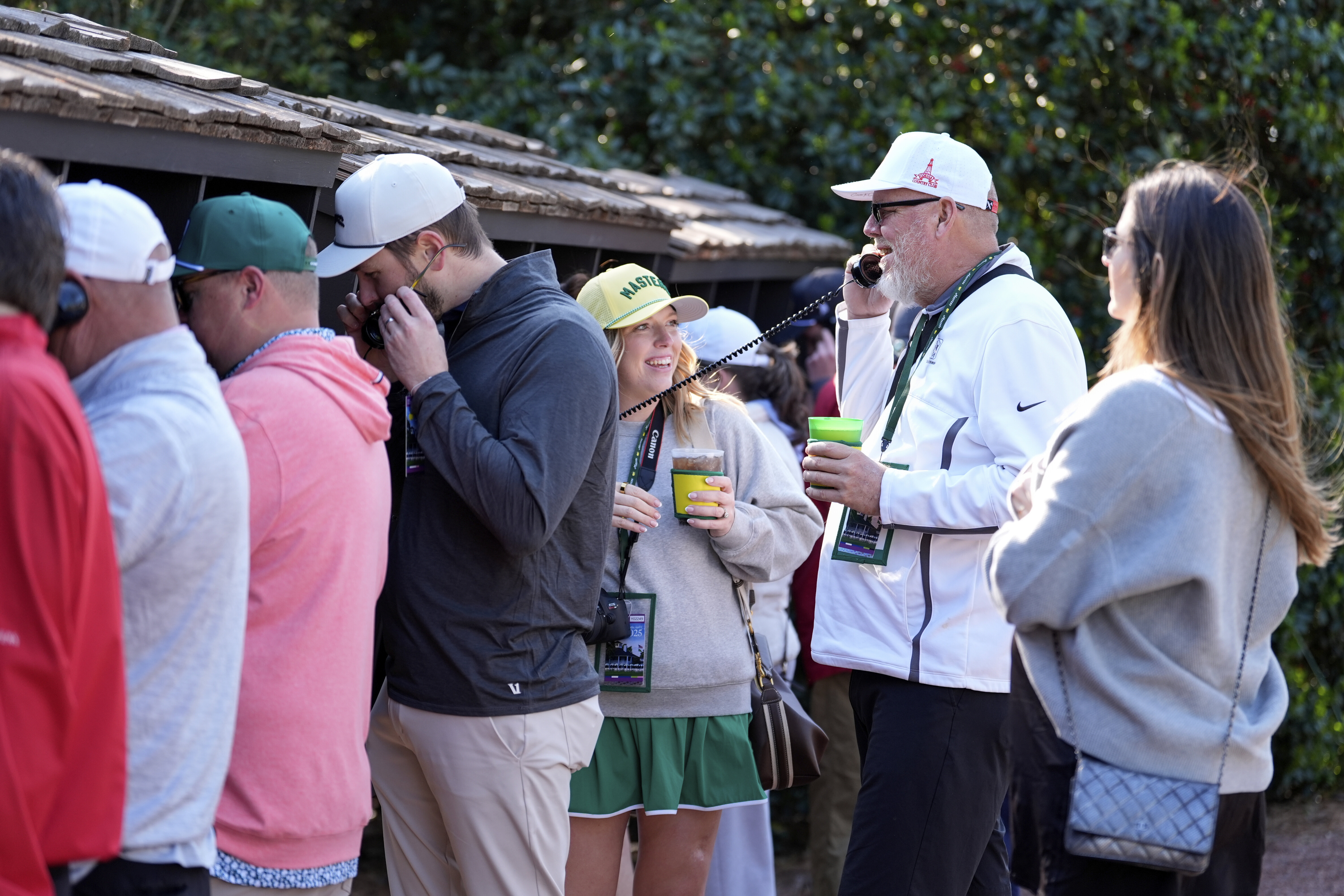 Patrons line up to use courtesy phones during a practice around at the Masters golf tournament, Wednesday, April 9, 2025, in Augusta, Ga.