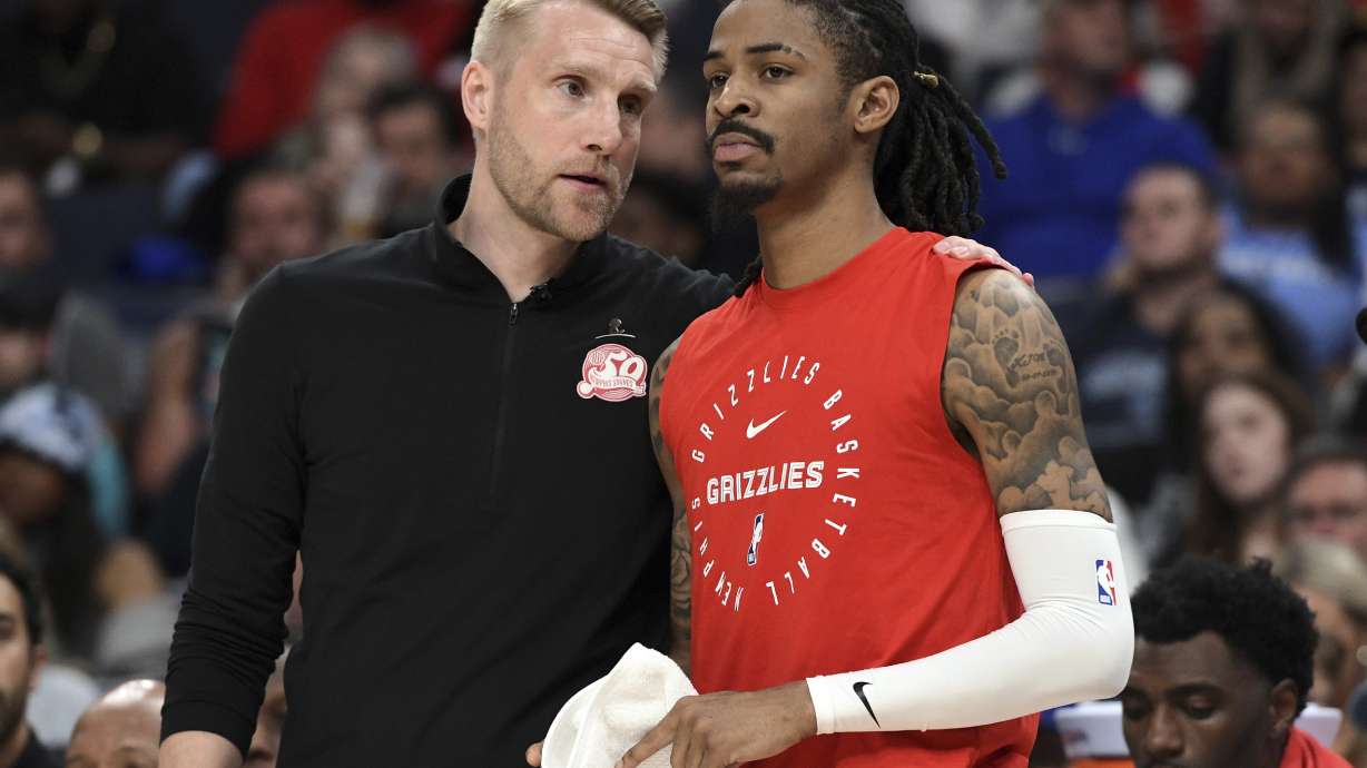 Memphis Grizzlies interim head coach Tuomas Iisalo, left, talks with guard Ja Morant, right, in the second half of an NBA basketball game against the Minnesota Timberwolves, Thursday, April 10, 2025, in Memphis, Tenn.
