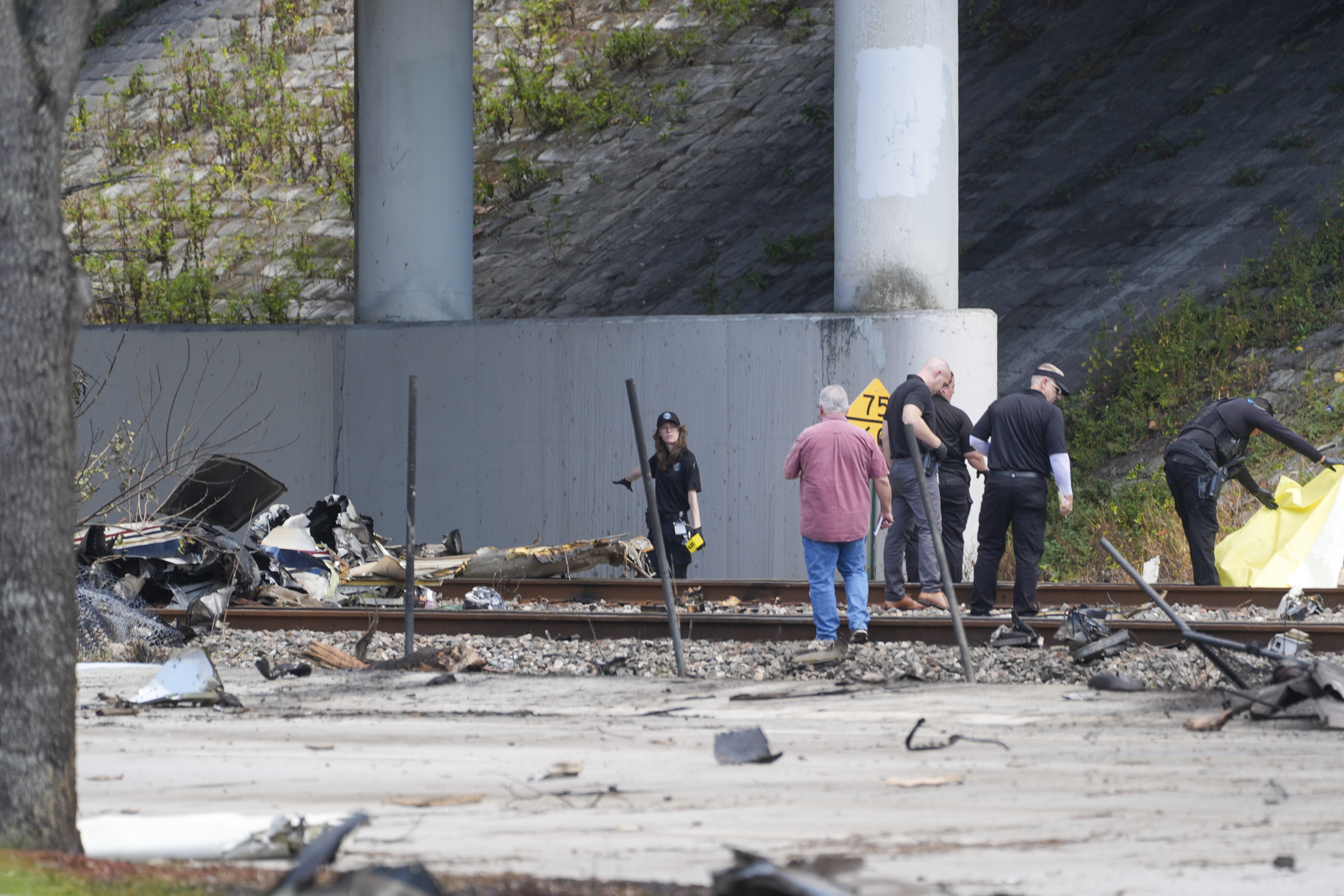 Emergency crews inspect the site of a small plane crash Friday in Boca Raton, Fla. Officials say three people were killed and one was injured.
