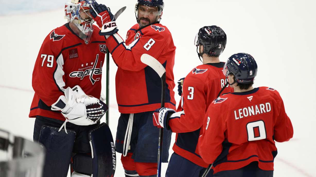 Washington Capitals left wing Alex Ovechkin (8) celebrates with goaltender Charlie Lindgren (79), defenseman Matt Roy (3) and right wing Ryan Leonard (9) after an NHL hockey game against the Carolina Hurricanes, Thursday, April 10, 2025, in Washington.