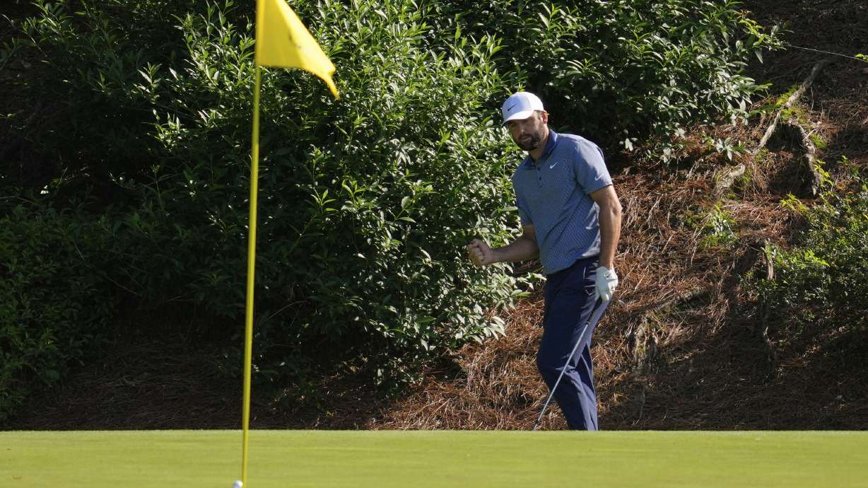 Scottie Scheffler celebrates after chipping in for birdie on the 12th hole during the second round at the Masters golf tournament, Friday, April 11, 2025, in Augusta, Ga.
