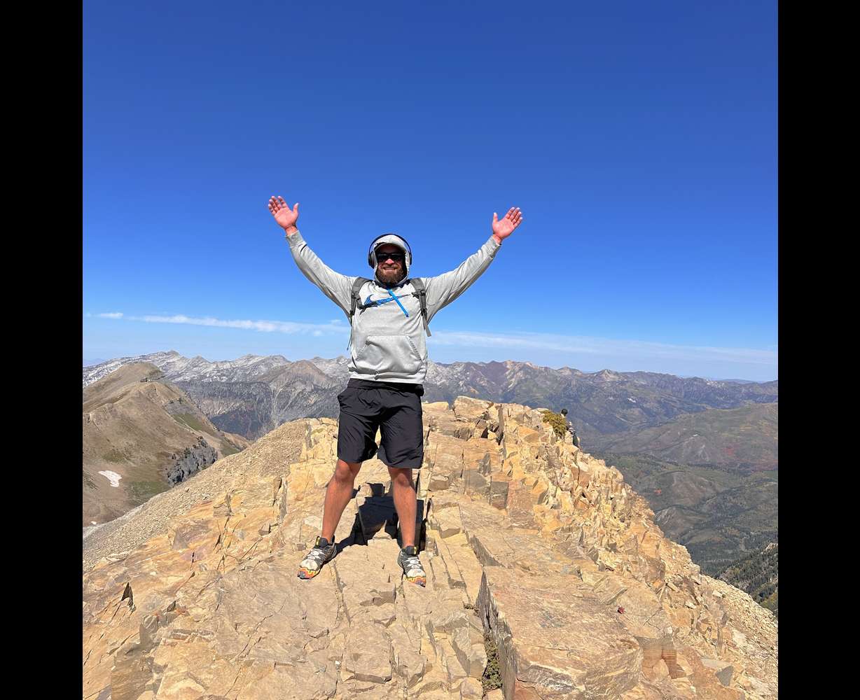 Provo hiker Tennison Hunter summits Mount Timpanogos in 2023. Hunter has found peace through reconnecting with nature.